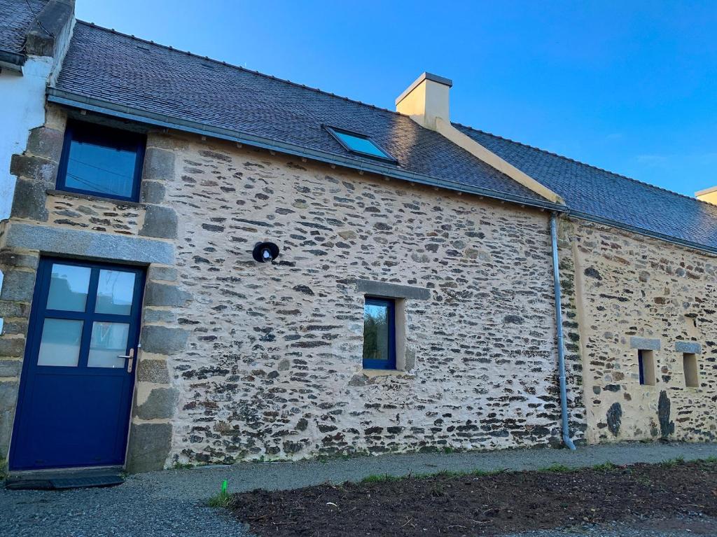 ein altes Steingebäude mit blauer Tür in der Unterkunft Penty - Charmante maison rénovée 50m de la mer à Banastère in Sarzeau