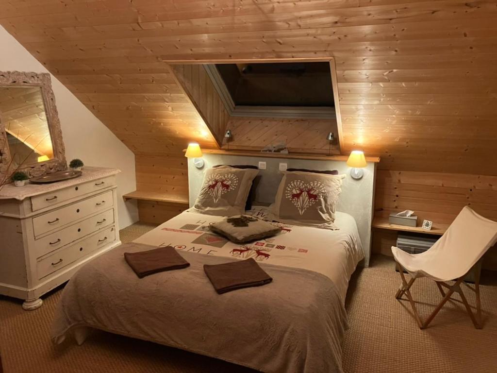 een slaapkamer met een groot bed, een dressoir en een stoel bij Le Cerf d'Argent in Saint-Andéol