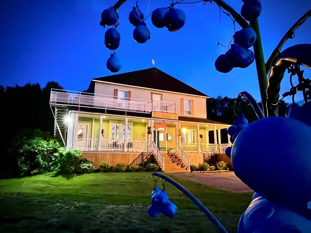 een huis met lichten aan de voorkant bij Auberge Presbytere Mont Lac-Vert in Hébertville