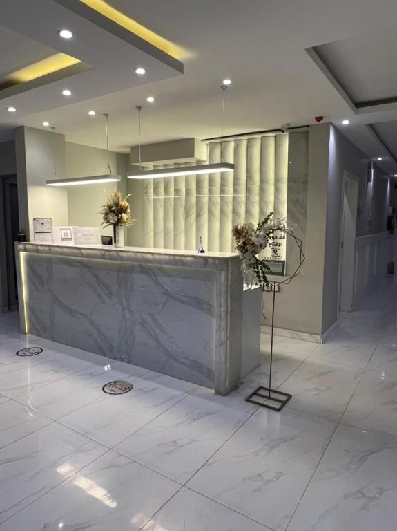 un vestíbulo con un gran mostrador de mármol en un edificio en Hotel Rest, en Abū Qa‘ar