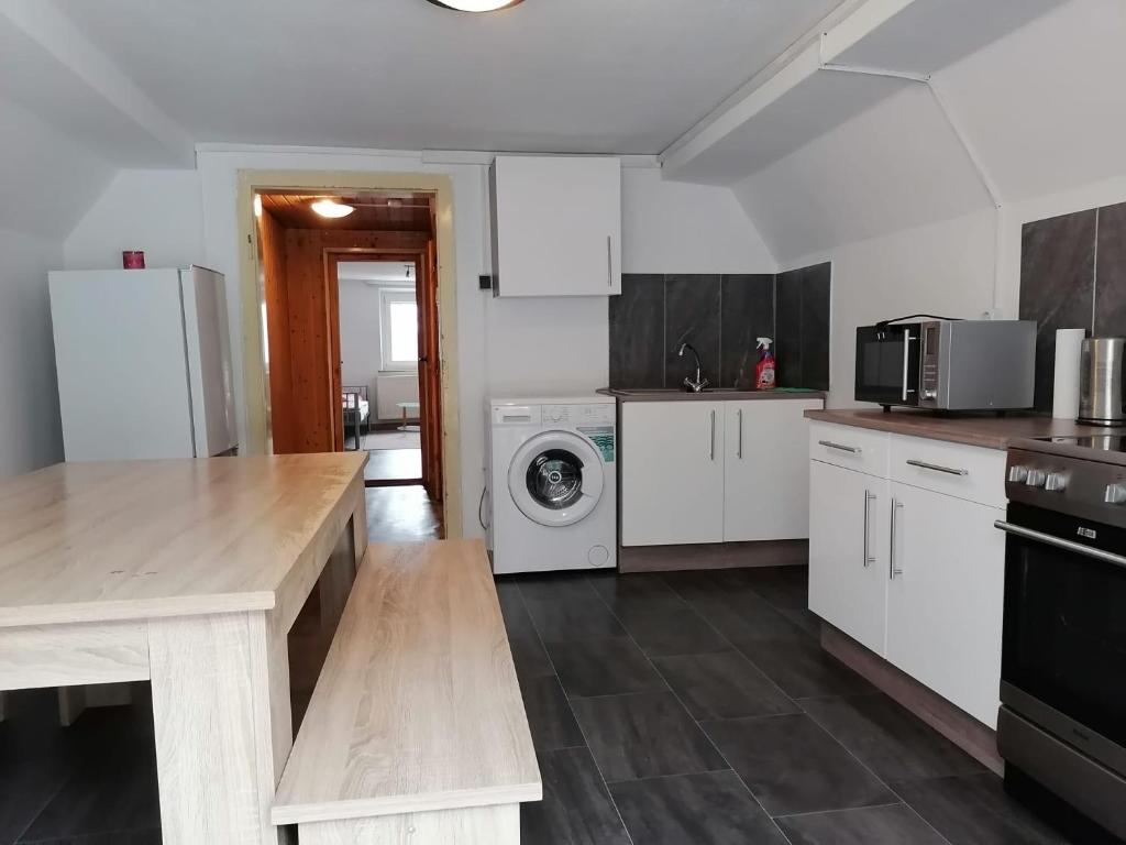 uma cozinha com armários brancos e uma máquina de lavar e secar roupa em Naab-Wohn em Nabburg