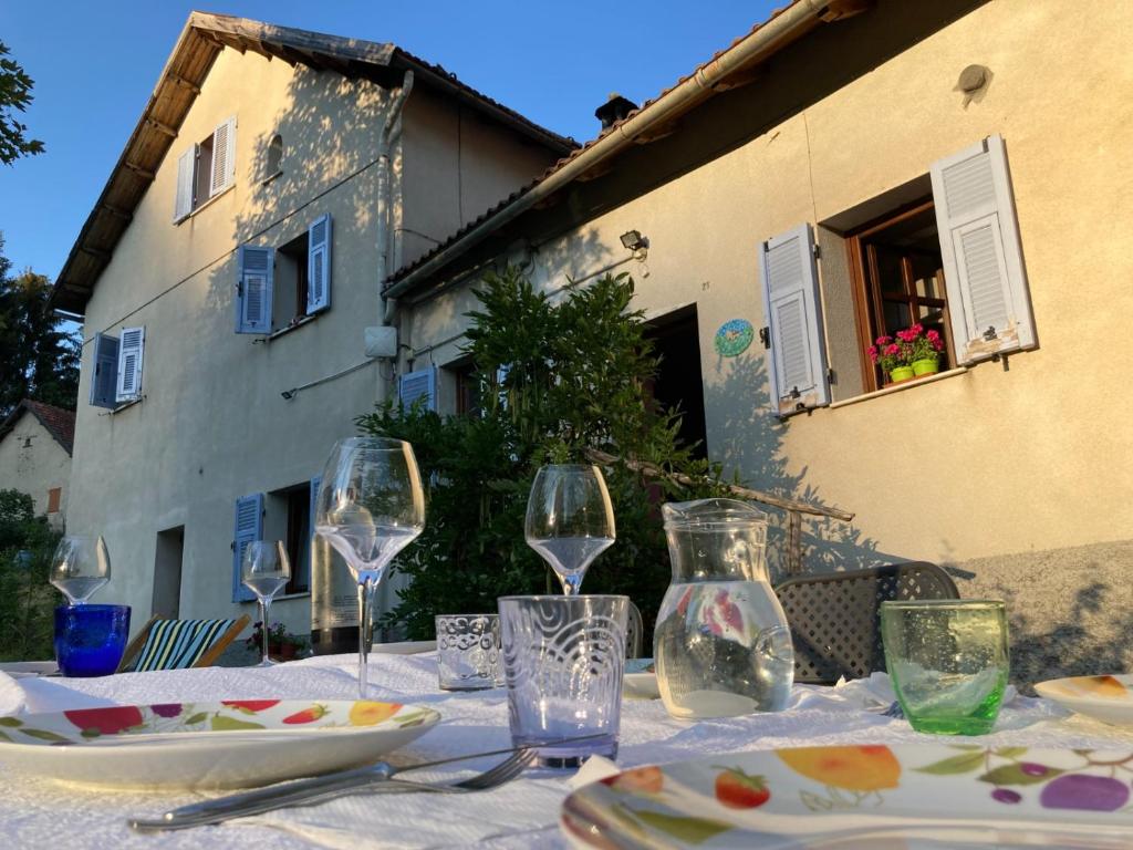 - une table avec des verres à vin et des assiettes dans l'établissement B&B La Scellana, à Tiglieto