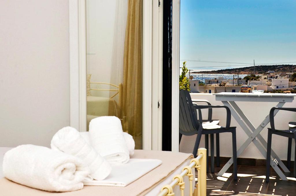 a room with a balcony with a view of a city at Louros rooms in Koufonisia