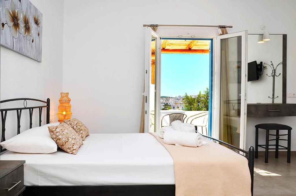 a bedroom with two beds and a balcony at Louros rooms in Koufonisia