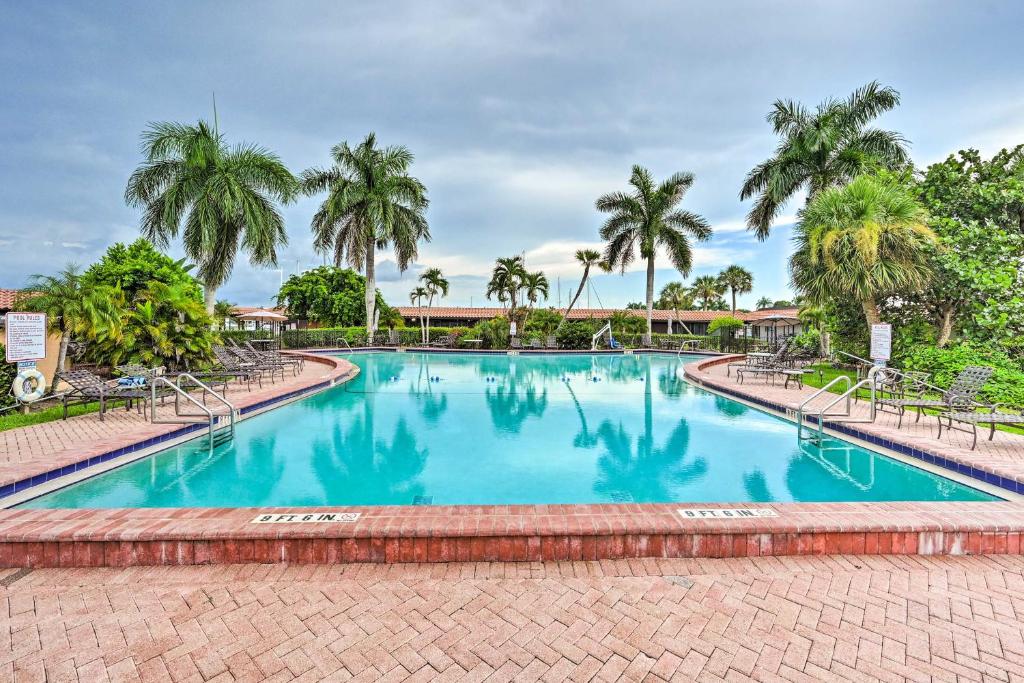una gran piscina con palmeras en el fondo en Naples Studio Near Everglades with Marina! en Naples