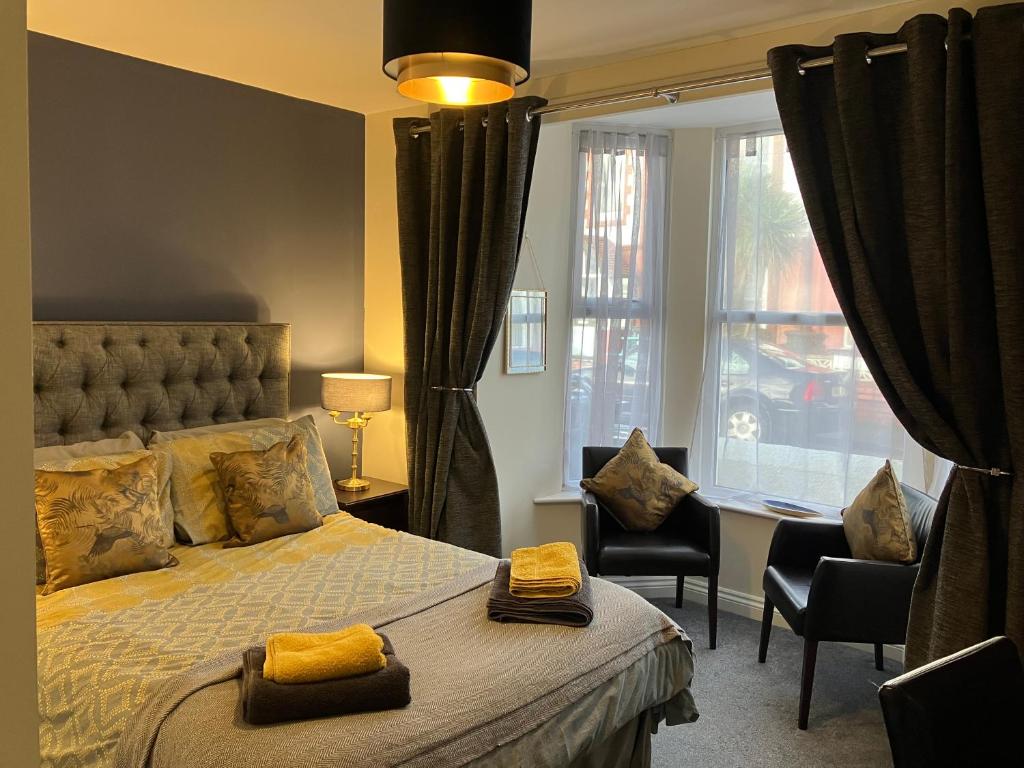 a bedroom with a bed and a desk and a window at THE PROMENADE SUITE - 2 min walk to the lovely beach front promernade of llandudno in Llandudno