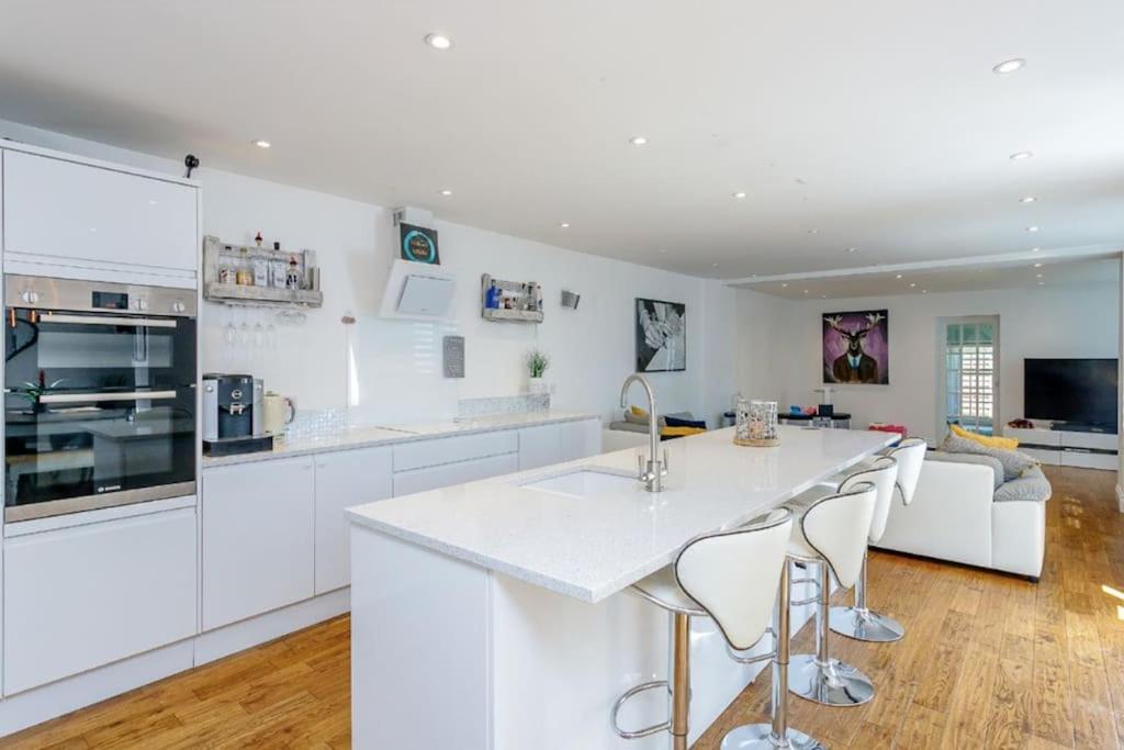 een keuken met witte kasten en een wit aanrecht bij Northampton Modern Oasis - Spacious & Stylish in Northampton