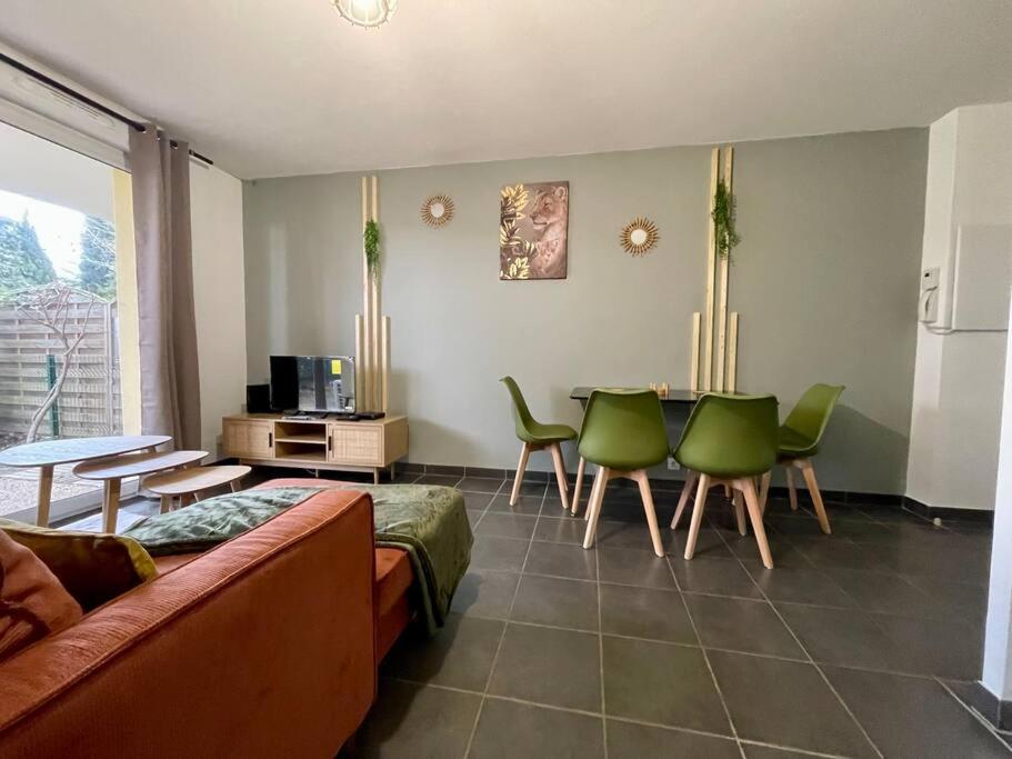 uma sala de estar com um sofá, uma mesa e cadeiras em La nature aux portes de Toulouse em Pinsaguel