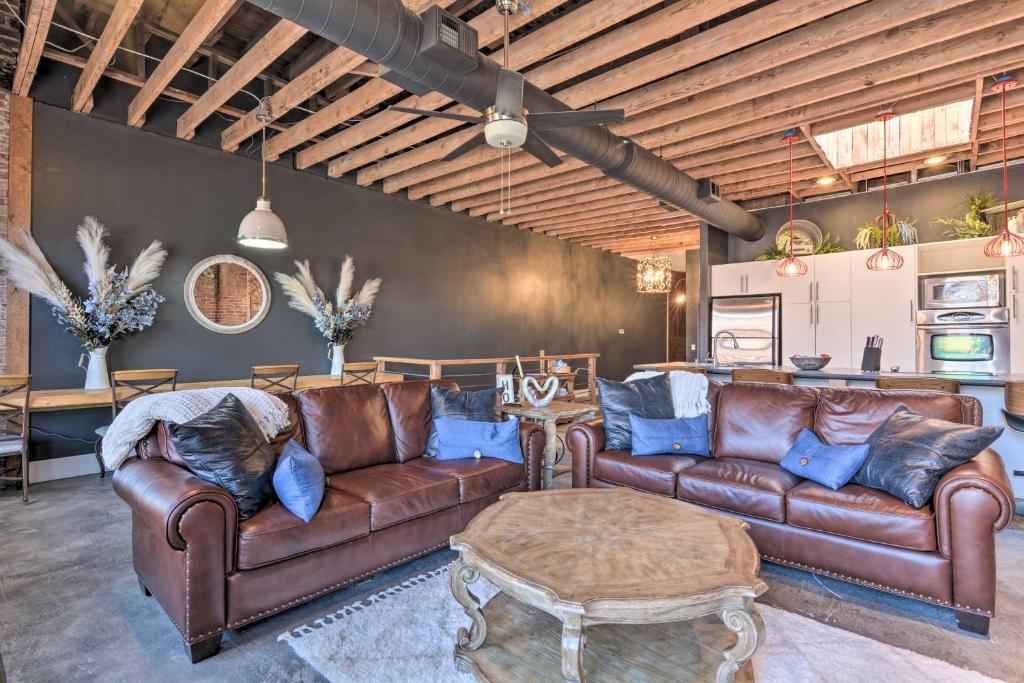 a living room with brown leather couches and a table at Upscale Loft in the Heart of Dtwn Springfield in Springfield