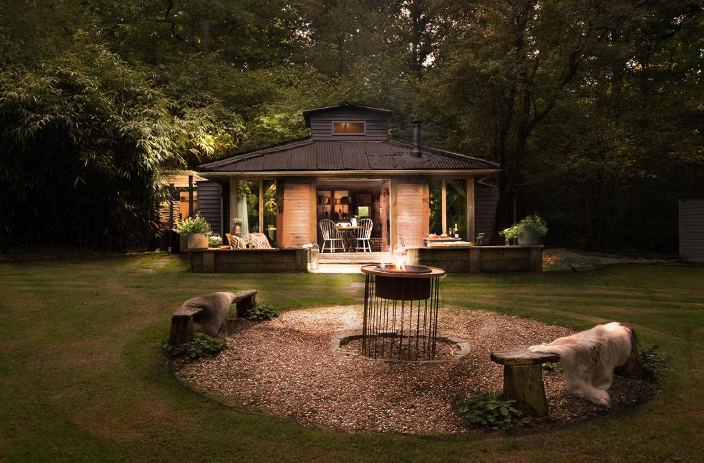 a small house with a dog statue in the yard at Luxury Boltholes cabin in the woods with hot tub 