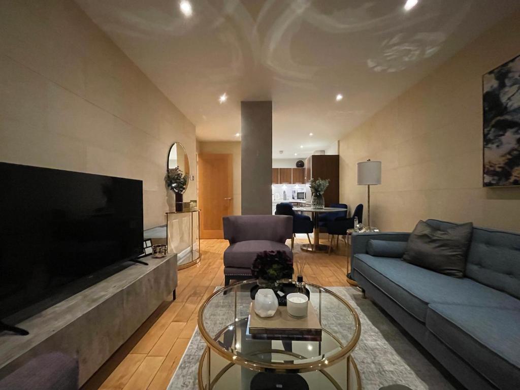 een woonkamer met een blauwe bank en een tv bij Stunning Westminster Apartment in Londen