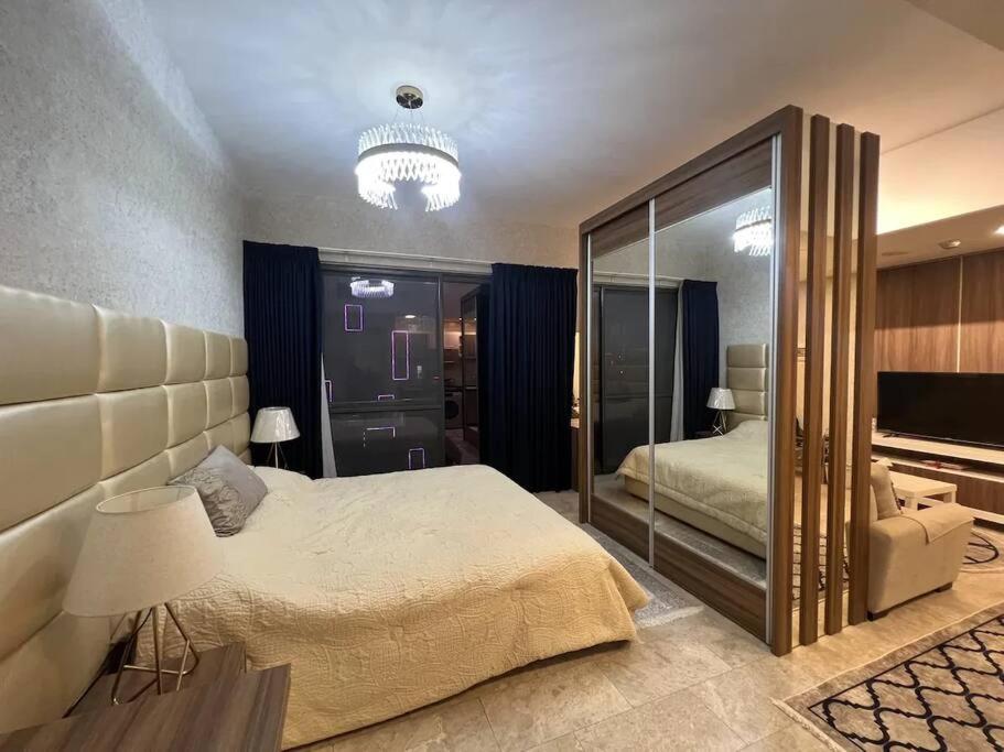 a bedroom with a large bed and a large mirror at Nice cozy studio in Damac Tower Amman 1104 in Amman