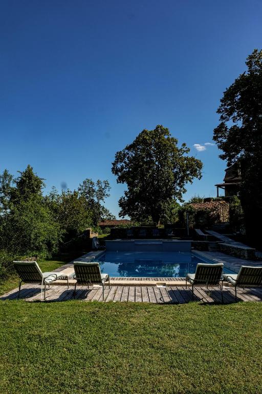 une piscine avec deux chaises et une table dans l'établissement Les Jardins de la Contie, à Lunan