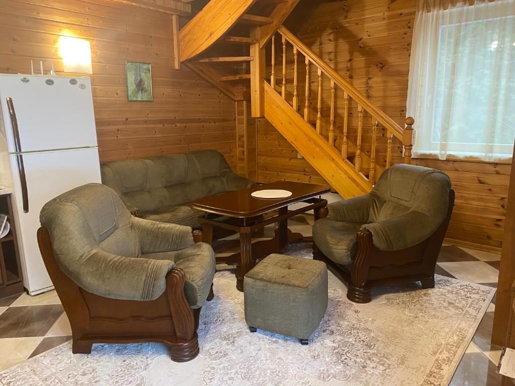 a living room with a couch and chairs and a table at VillaSun in Baloži