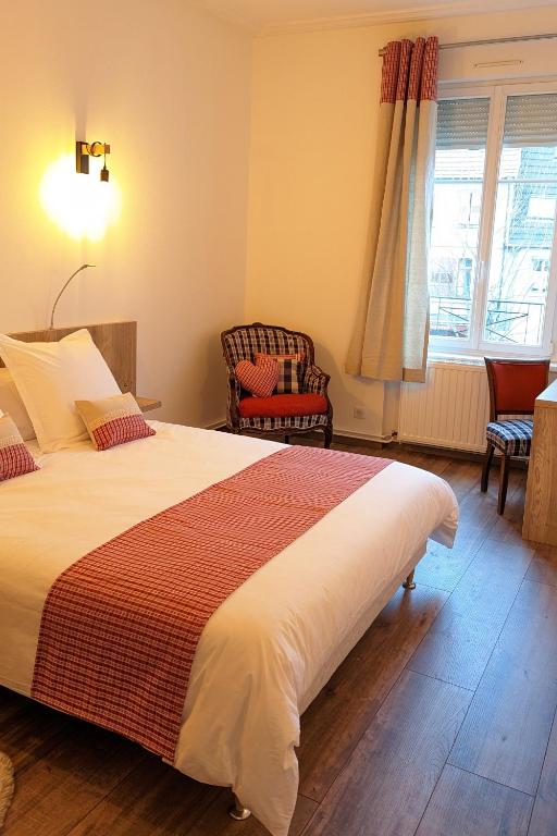 une chambre avec un lit et deux chaises et une fenêtre dans l'établissement Appartement Chez Mar'Tine, à Niederbronn-les-Bains