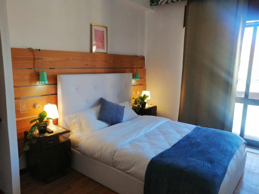 - une chambre avec un grand lit et une tête de lit en bois dans l'établissement Porto Grand Sasimi House, à Porto