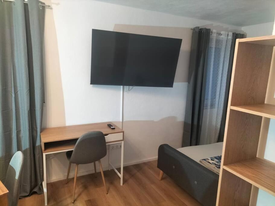 Habitación con escritorio y TV en la pared. en Ferienwohnung Luitpold 2 en Memmingen