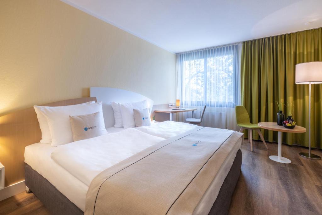 a hotel room with a large bed and a window at Select Hotel Erlangen in Erlangen