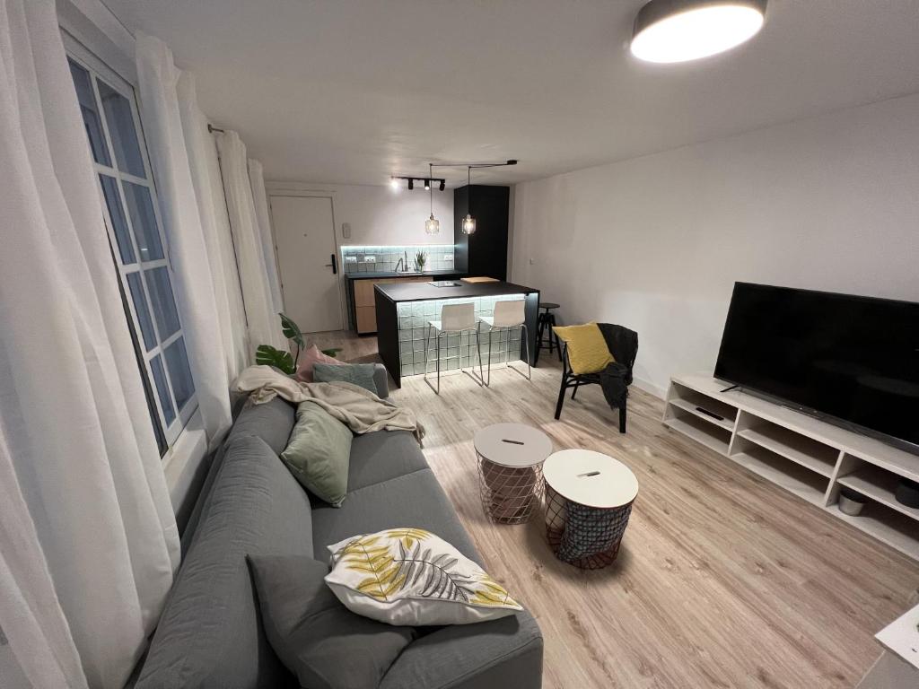 un soggiorno con divano e TV a schermo piatto di Patiovecino Apartment Centro de Cádiz a estrenar a Cadice