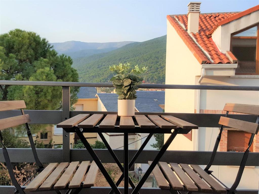 une table en bois avec une plante au-dessus d'un balcon dans l'établissement Casa del Castillo by Naturadrada, à La Adrada