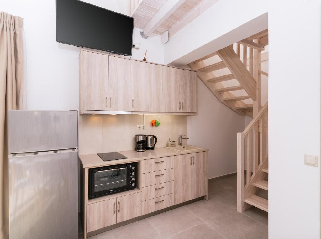 a kitchen with wooden cabinets and a refrigerator at Matala Prime Villas in Matala