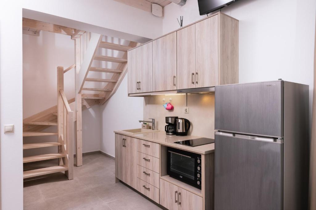 a kitchen with a stainless steel refrigerator and a staircase at Matala Prime Villas in Matala