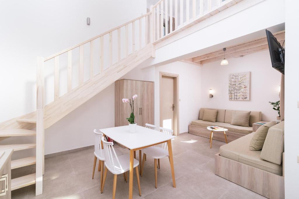 a living room with a staircase and a table and chairs at Matala Prime Villas in Matala