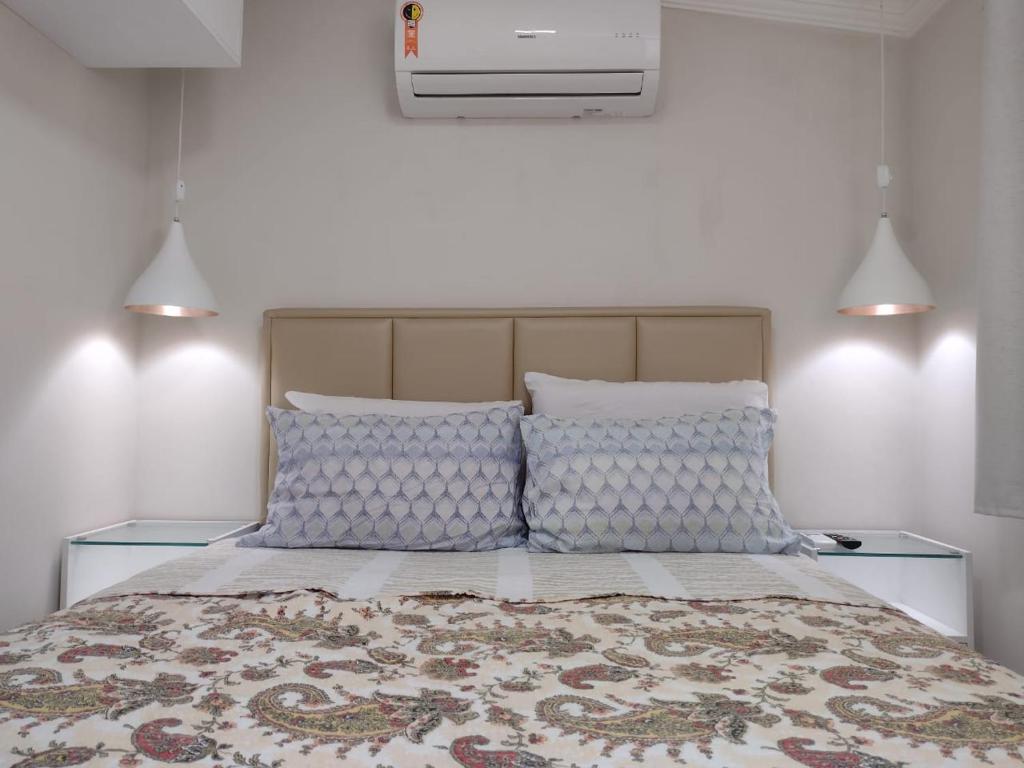 um quarto com uma cama com almofadas azuis e brancas em Flat Beach Selma em Porto de Galinhas
