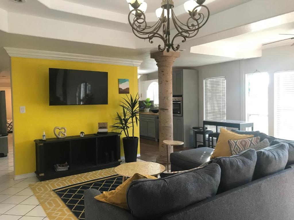 a living room with a couch and a tv at Cheerful 4 bedroom home with pool and BBQ area with 5th bedroom option in Brownsville