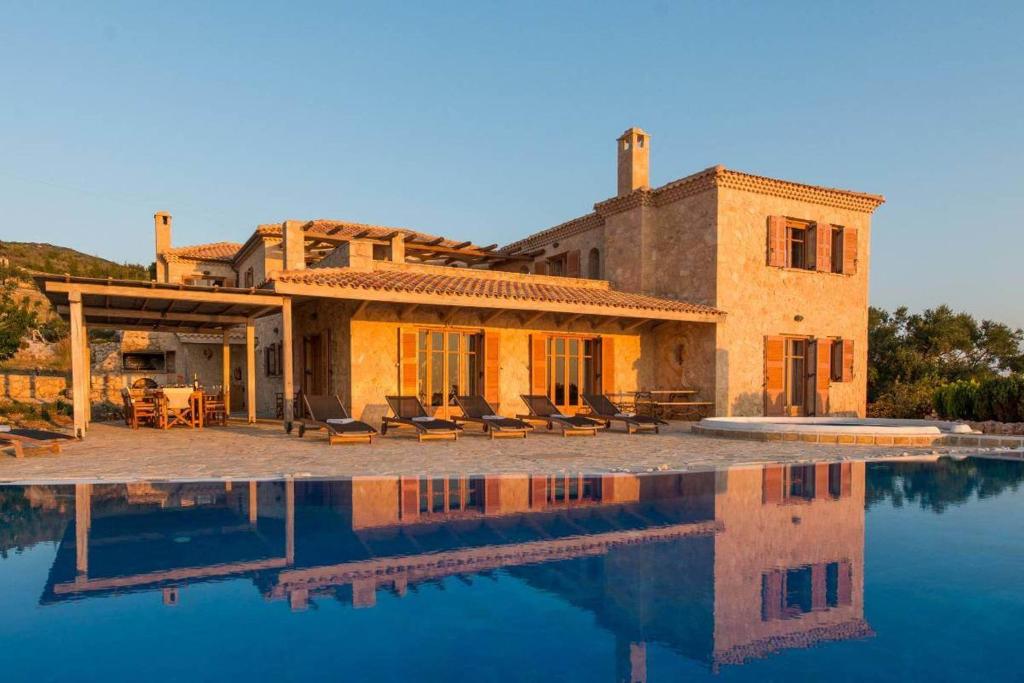 a house with a swimming pool in front of it at Astarte Villas - Diva Affluence with Private Pool in Koríthion