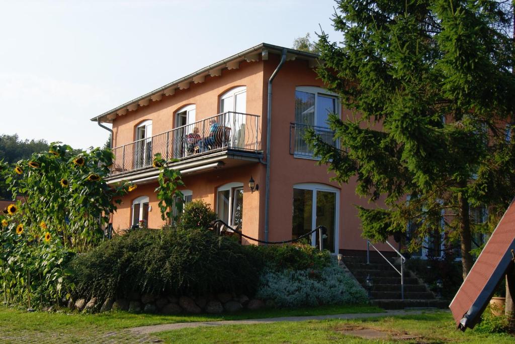 a house with a balcony on top of it at Pension Waldeck in Göhren
