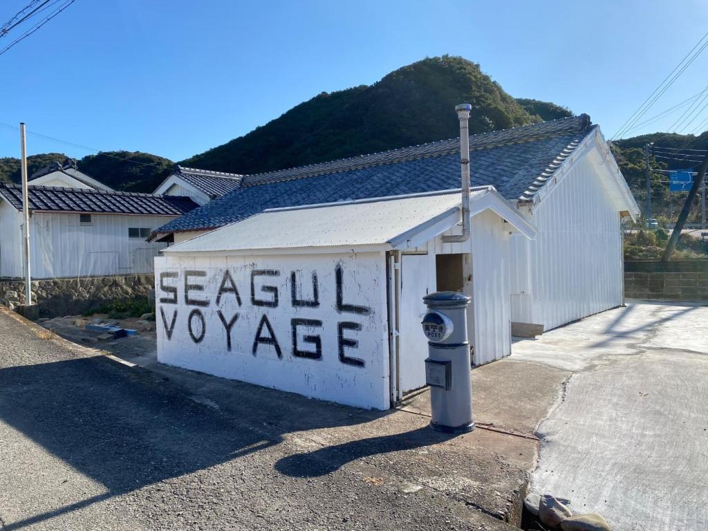 ein weißes Gebäude mit einem Schild mit einer Parkuhr in der Unterkunft Seagull voyage - Vacation STAY 43030v in Hiki