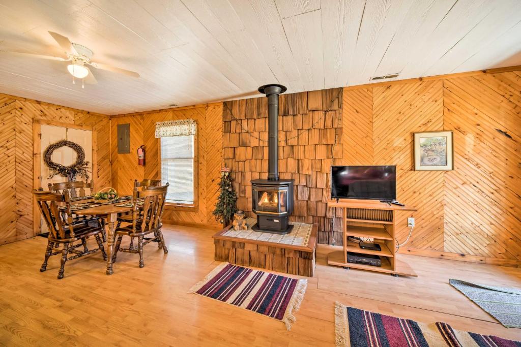 - un salon avec une cuisinière, une table et une télévision dans l'établissement The Burgundy Cabin Iowa Retreat Pond and Fire Pit, à Spragueville