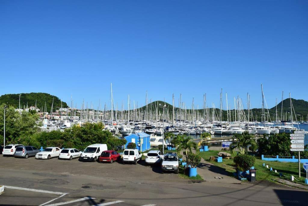a parking lot with cars parked in a marina at Omarina in Le Marin