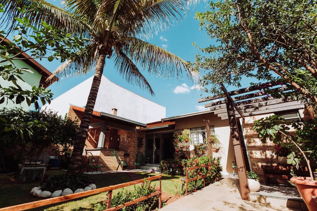 une maison avec un palmier en face dans l'établissement Casa c churrasq em Monte Castelo, Campo Grande-MS, à Campo Grande