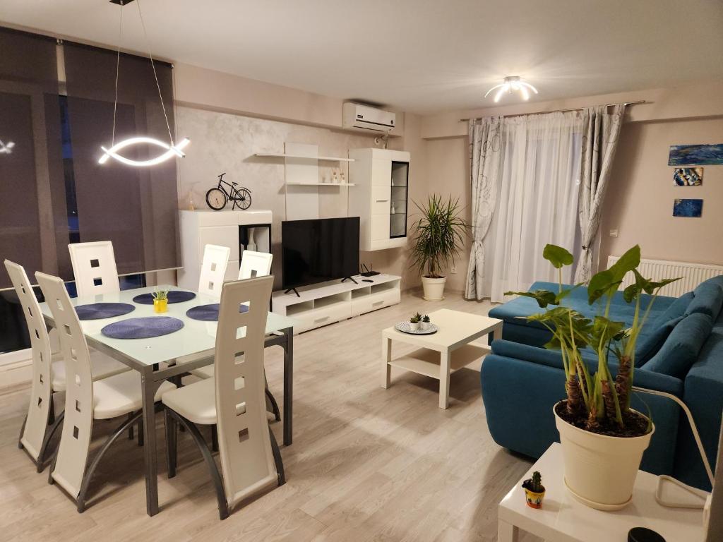 a living room with a table and a blue couch at Airport Apartment Otopeni in Otopeni