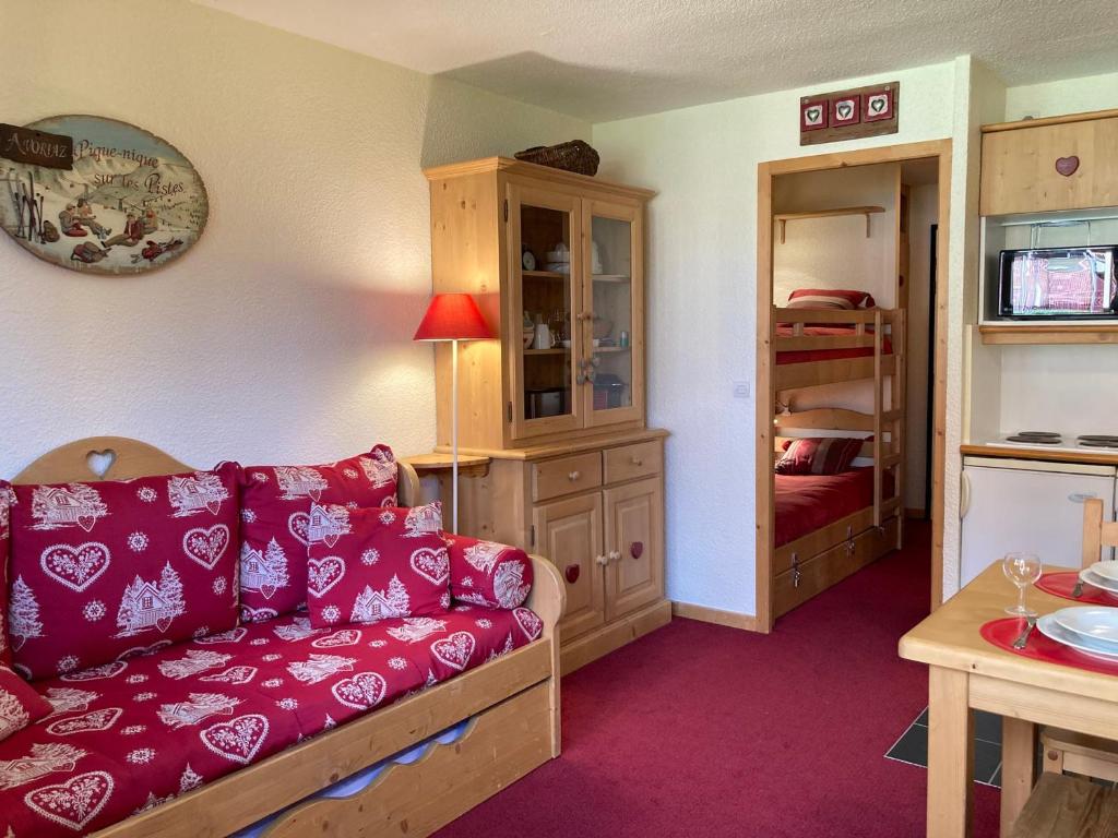 a living room with a red couch and a bedroom at Studio Avoriaz, 1 pièce, 4 personnes - FR-1-634-68 in Avoriaz