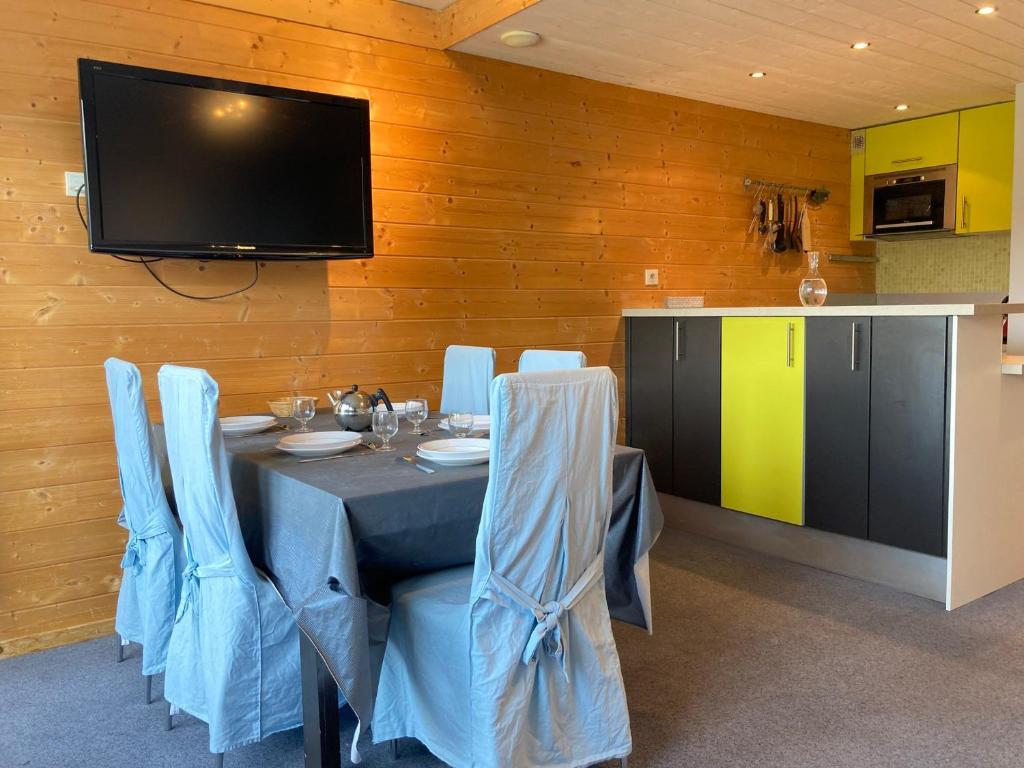d'une salle à manger avec une table, des chaises et une télévision. dans l'établissement Agréable duplex 3 pièces, centre station, balcon sud, 5 pers. - FR-1-634-64, à Avoriaz