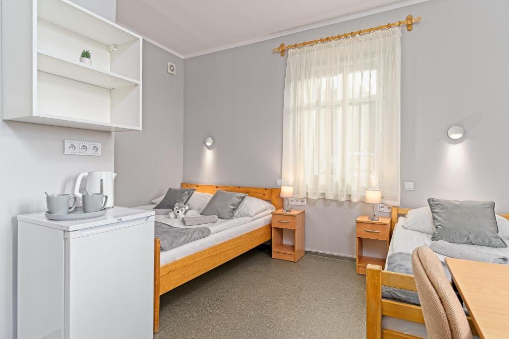 コバリにあるOśrodek WOJKÓW Kowary koło Karpaczaのベッドルーム1室(ベッド2台、テーブル付)、キッチン