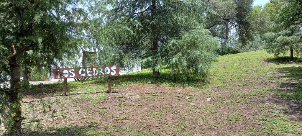 a sign in the middle of a field with trees at Los Cedros in Cordoba