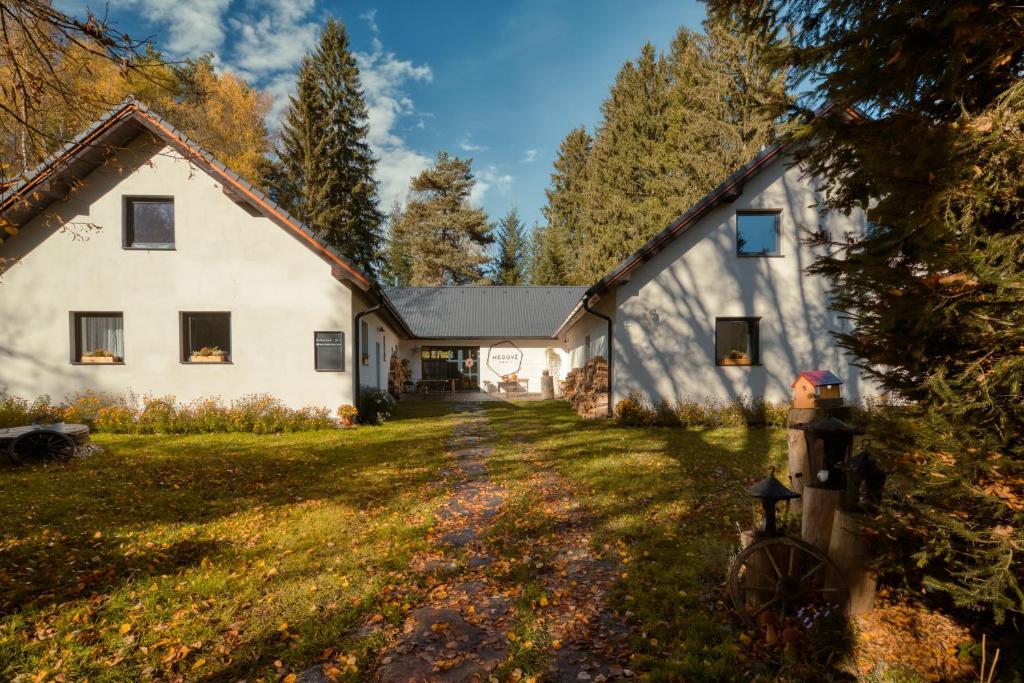 uma grande casa branca com um quintal em Penzion Medové údolí em Čábuze