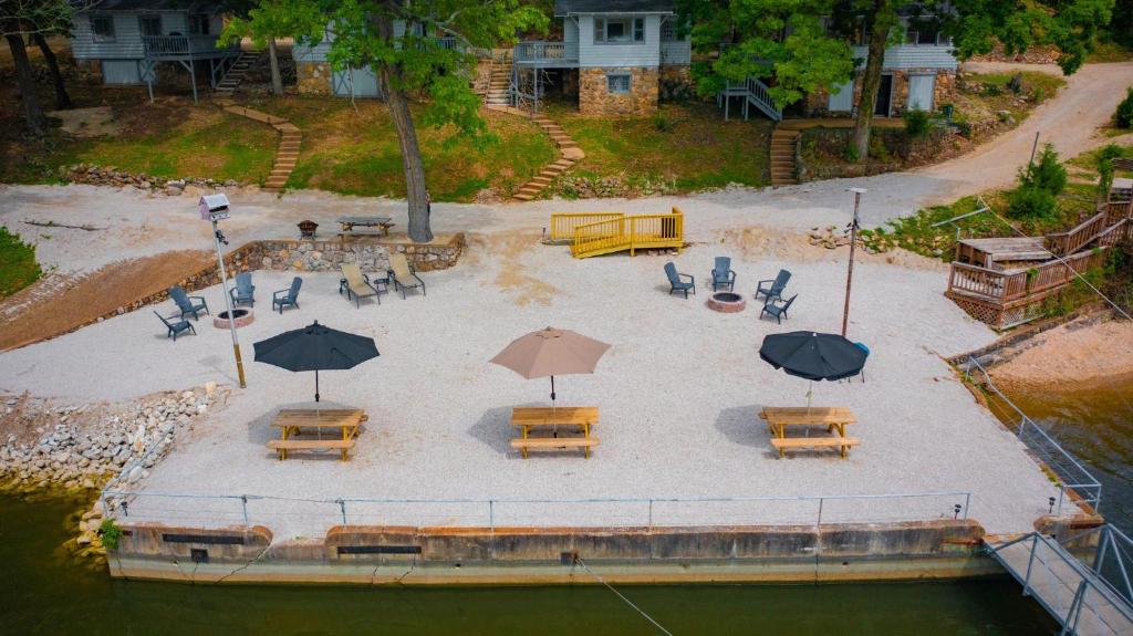 an aerial view of a patio with tables and umbrellas at Lakeshore Fishing Cabin #3, Ramp, dock, fire pit in Lake Ozark
