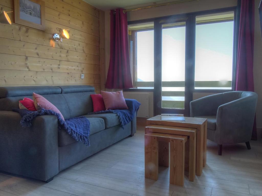 una sala de estar con un sofá y una mesa en Appartement 3 pièces pour 6/7 pers avec 2 salles de bains, buanderie, casier à skis et wifi - FR-1-634-11, en Morzine