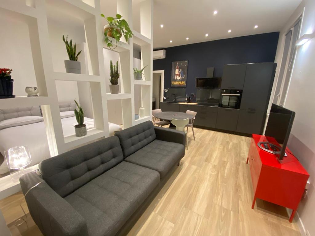 un soggiorno con divano grigio e tavolo rosso di #milanodabere Urban Loft a Milano