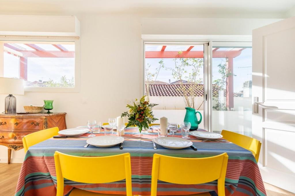 ein Esszimmer mit einem Tisch und gelben Stühlen in der Unterkunft Balkoia superbe appartement de 75 m2 entièrement rénové in Saint-Jean-de-Luz
