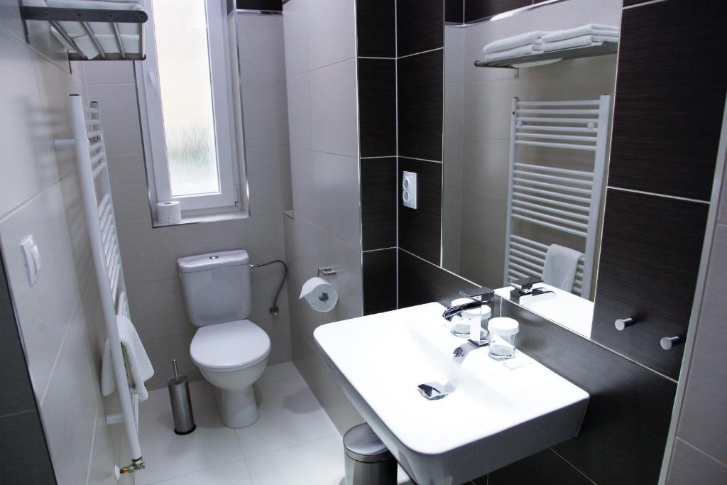 a bathroom with a white sink and a toilet at Pension Dvořák in Karlovy Vary