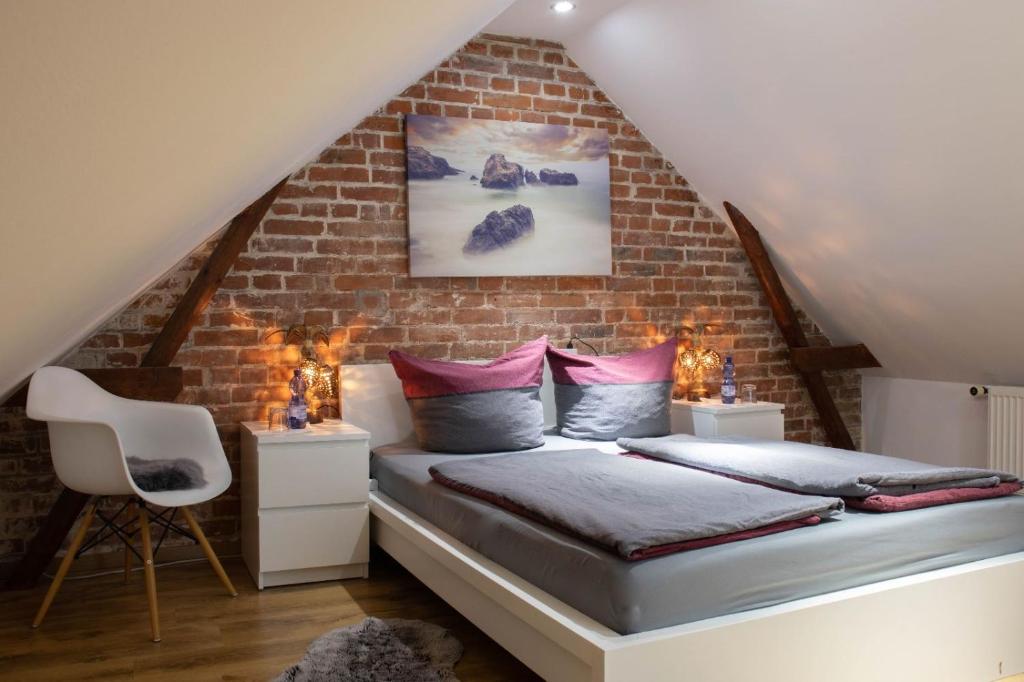 1 dormitorio con 1 cama en una pared de ladrillo en Kleine gemütliche Einliegerwohnung mit Garten und Pool en Nordstemmen