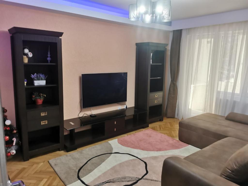 a living room with a television and a couch at Casa Potcoava in Târgu-Mureş