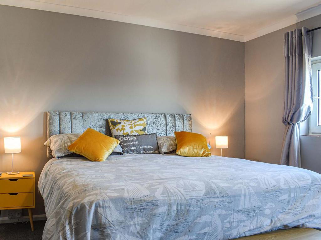 a bedroom with a large bed with yellow pillows at Helens View in Torpoint