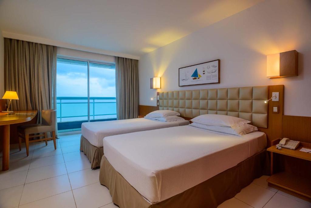 una camera d'albergo con due letti e vista sull'oceano di Hotel Luzeiros São Luis a São Luís